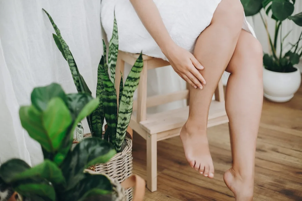 Legs with a green plant and a towel