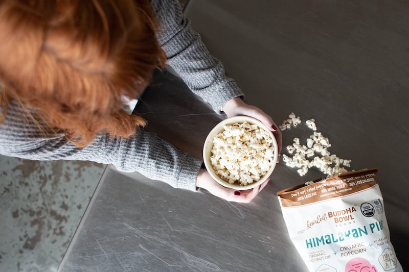 Photo of a woman eating popcorn.