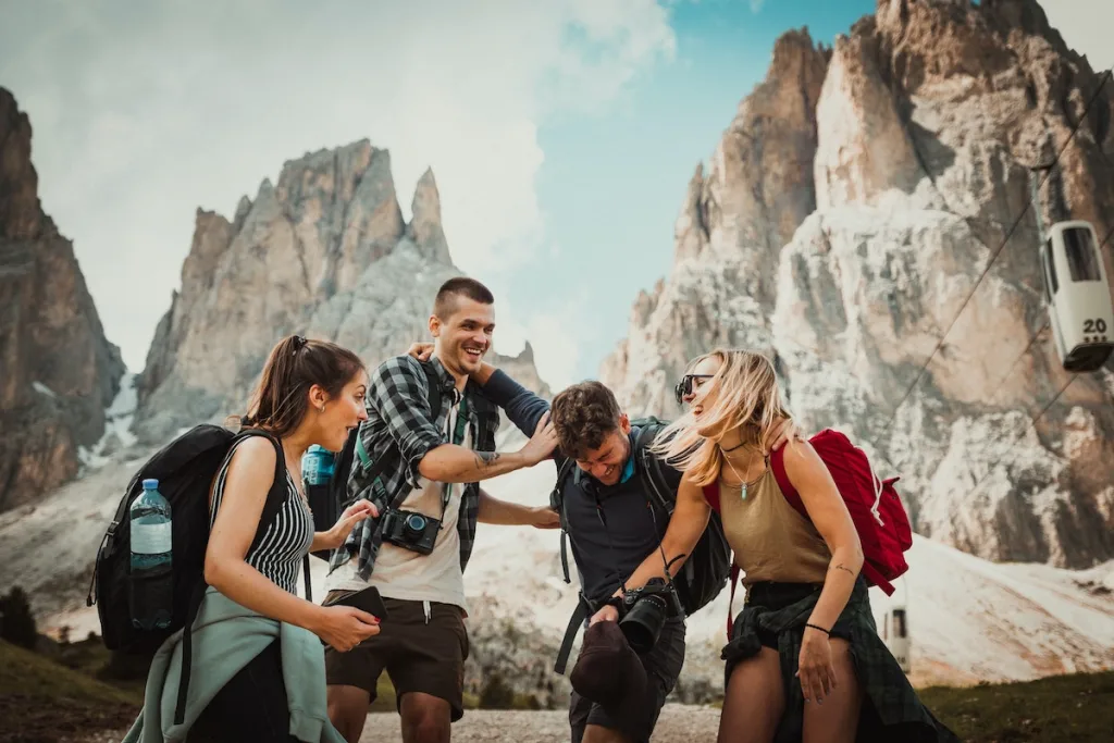 A group of men and women laughing with mountains in the background