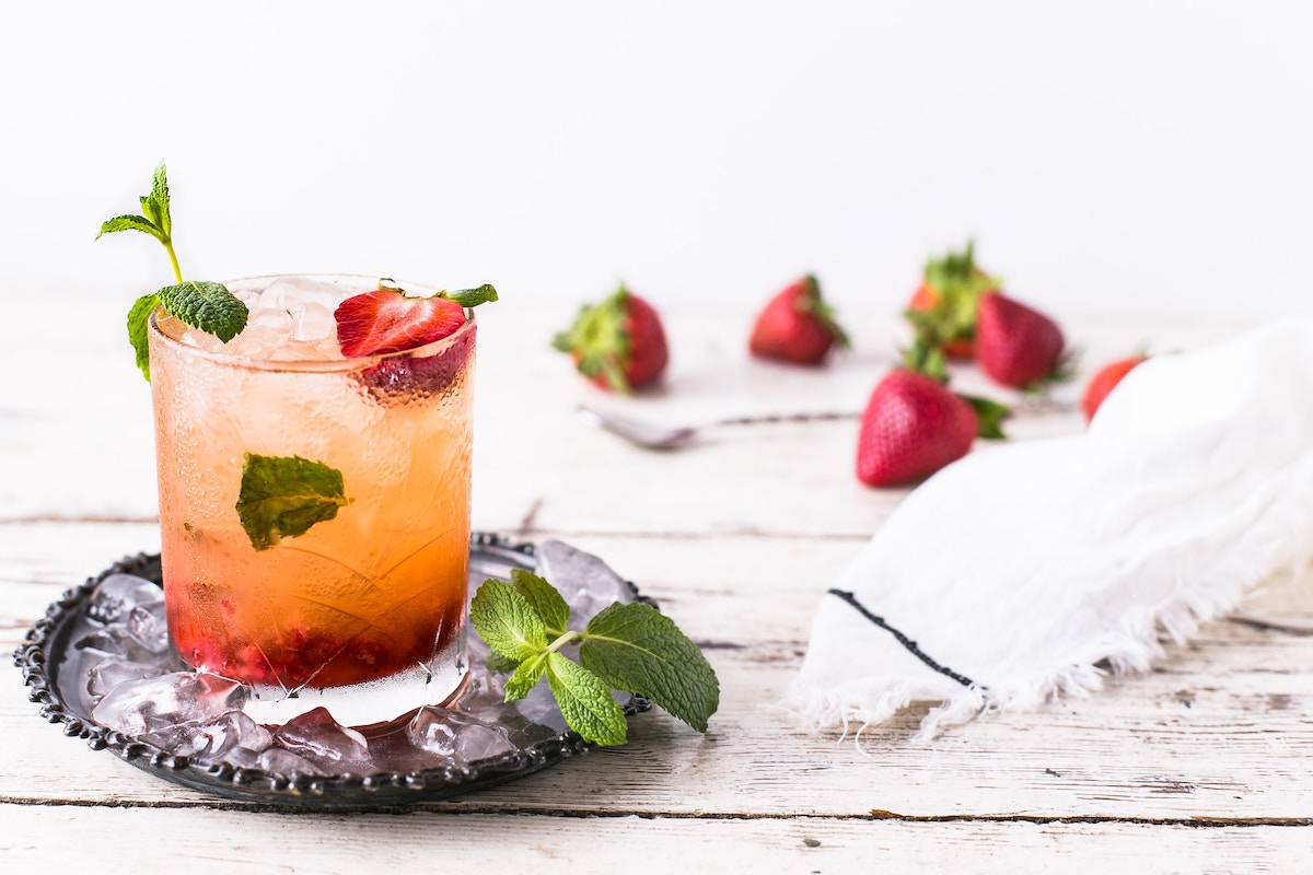 pink mocktail with strawberries and mint on a white background