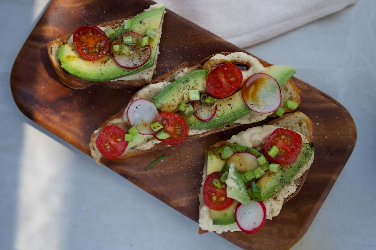 Breakfast toast with egg, avocado, and tomatoes.