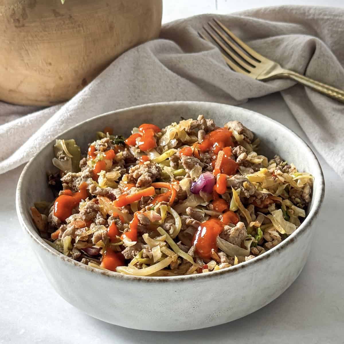 close up side view of egg roll in a bowl.