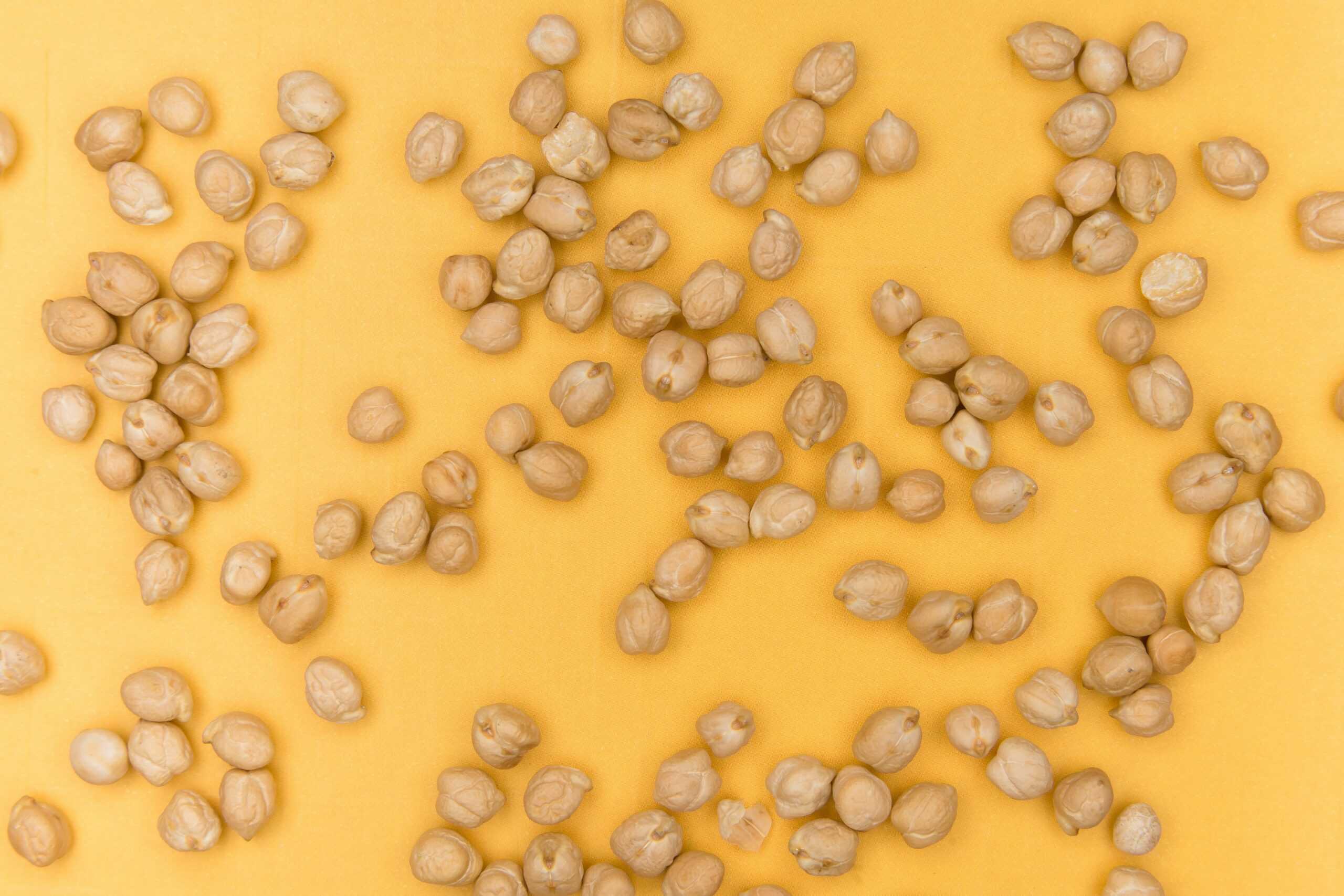 Chickpeas on a yellow backdrop. They are one of the top 10 foods for mental health.
