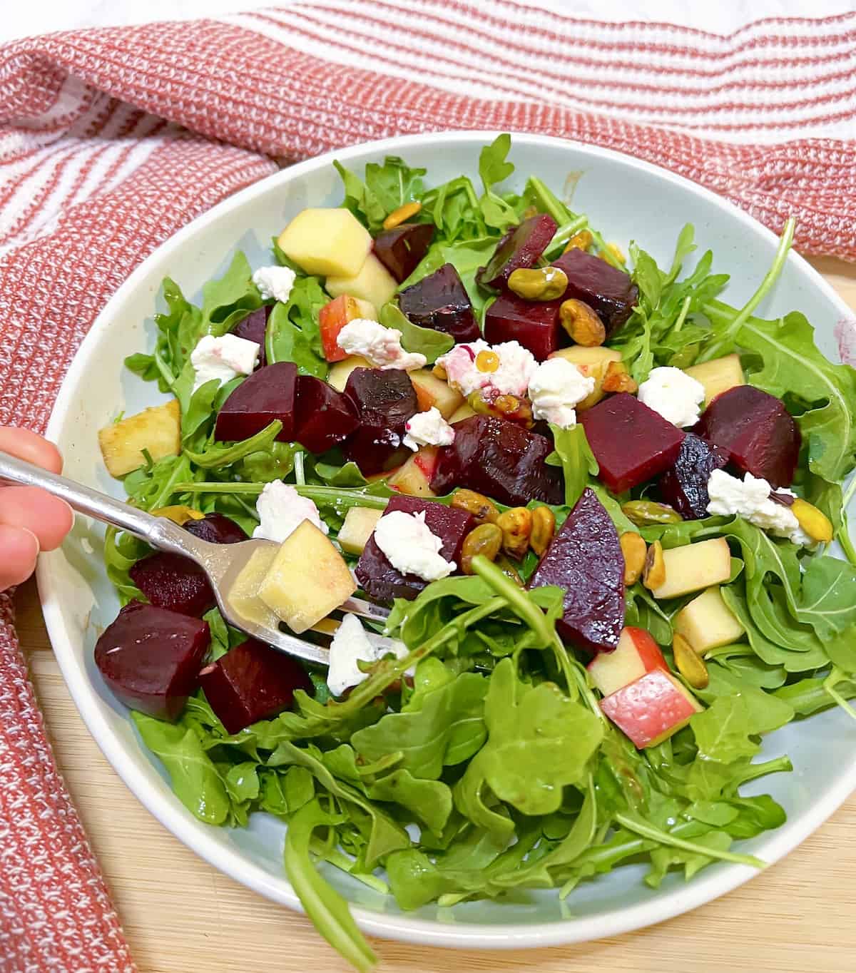 Beet and Arugula salad with goat cheese with a fork in it