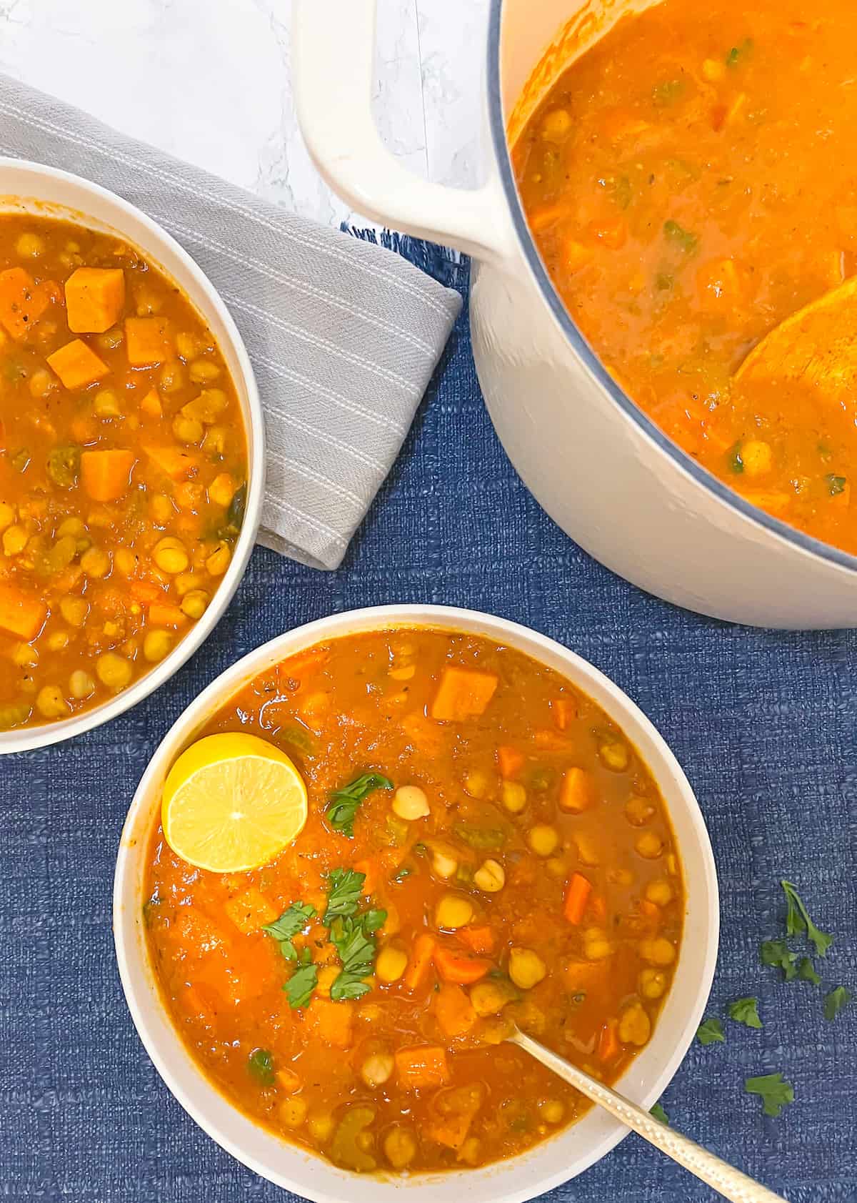 vegan smoky mediterranean chickpea soup in a white bowl with a spoon in it
