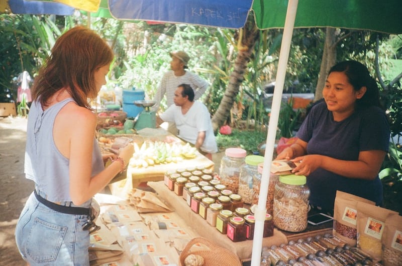 A girl buying from a vendor at a Farmer's Market