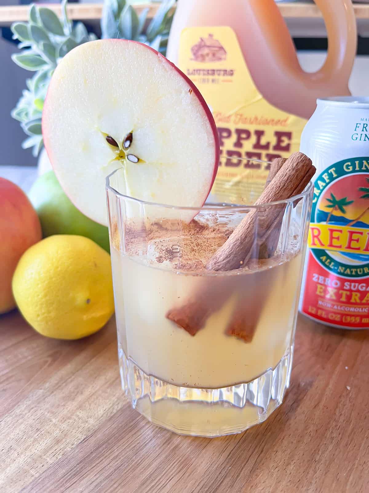 apple mocktail with lemon, apple cider, ginger beer, and an apple slice