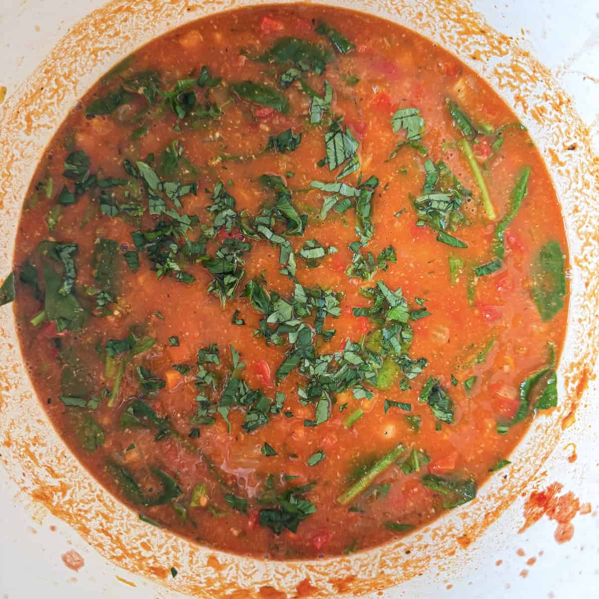 overhead view of lemon and parsley added to a large pot of soup.