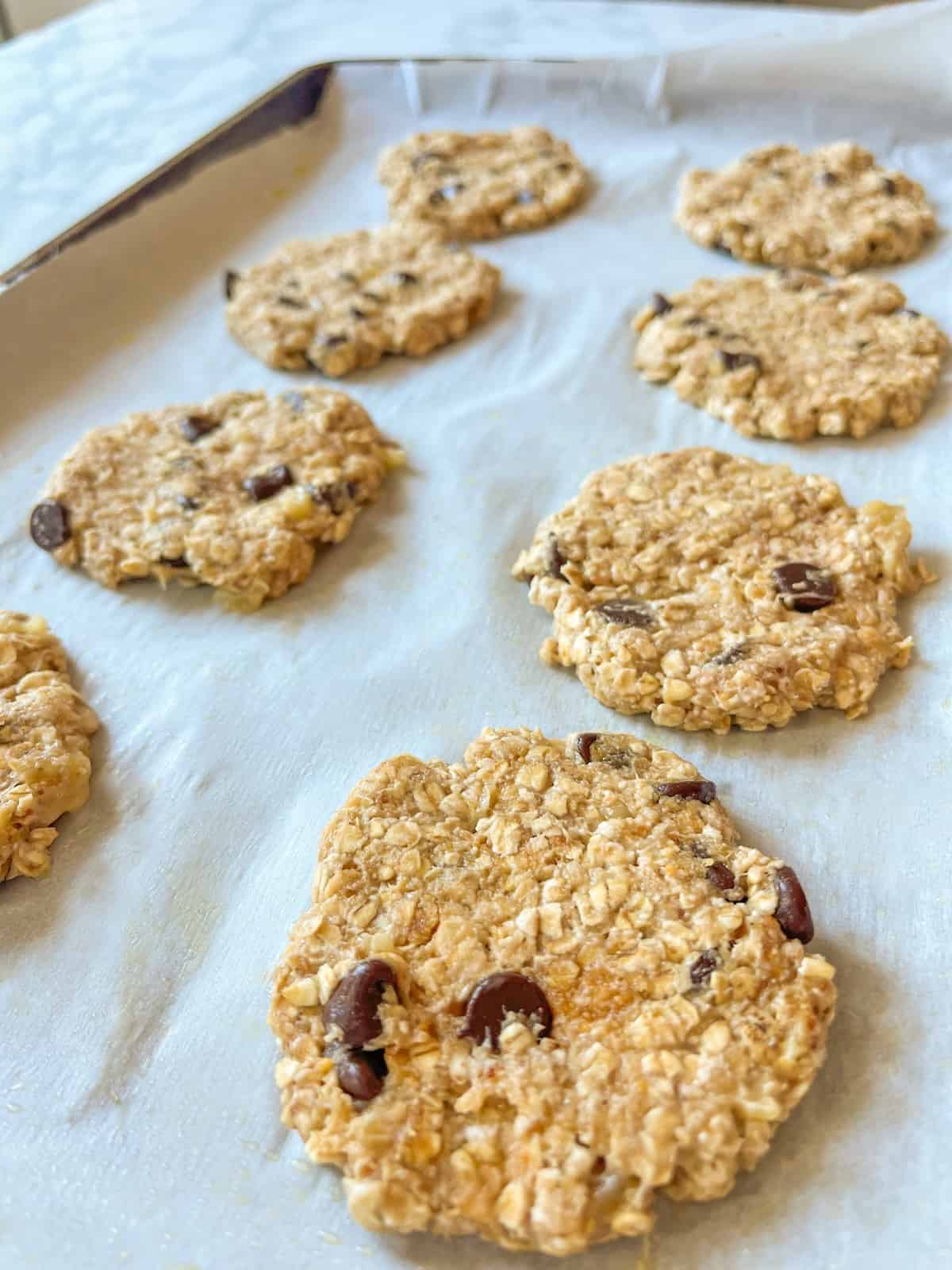 4 ingredient healthy banana oatmeal cookies on a baking sheet with parchment paper