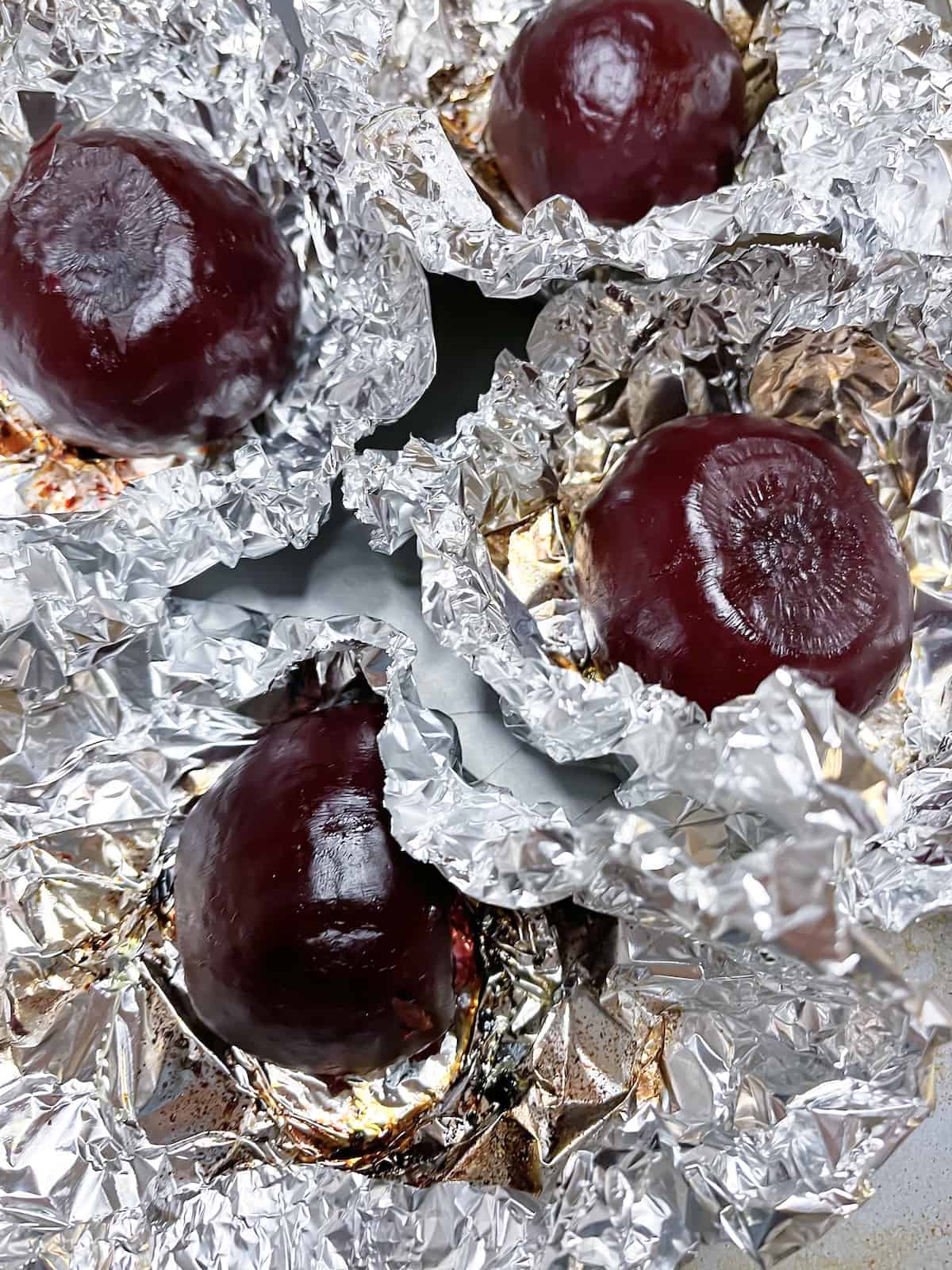 Roasted beets in foil with the foil packets open