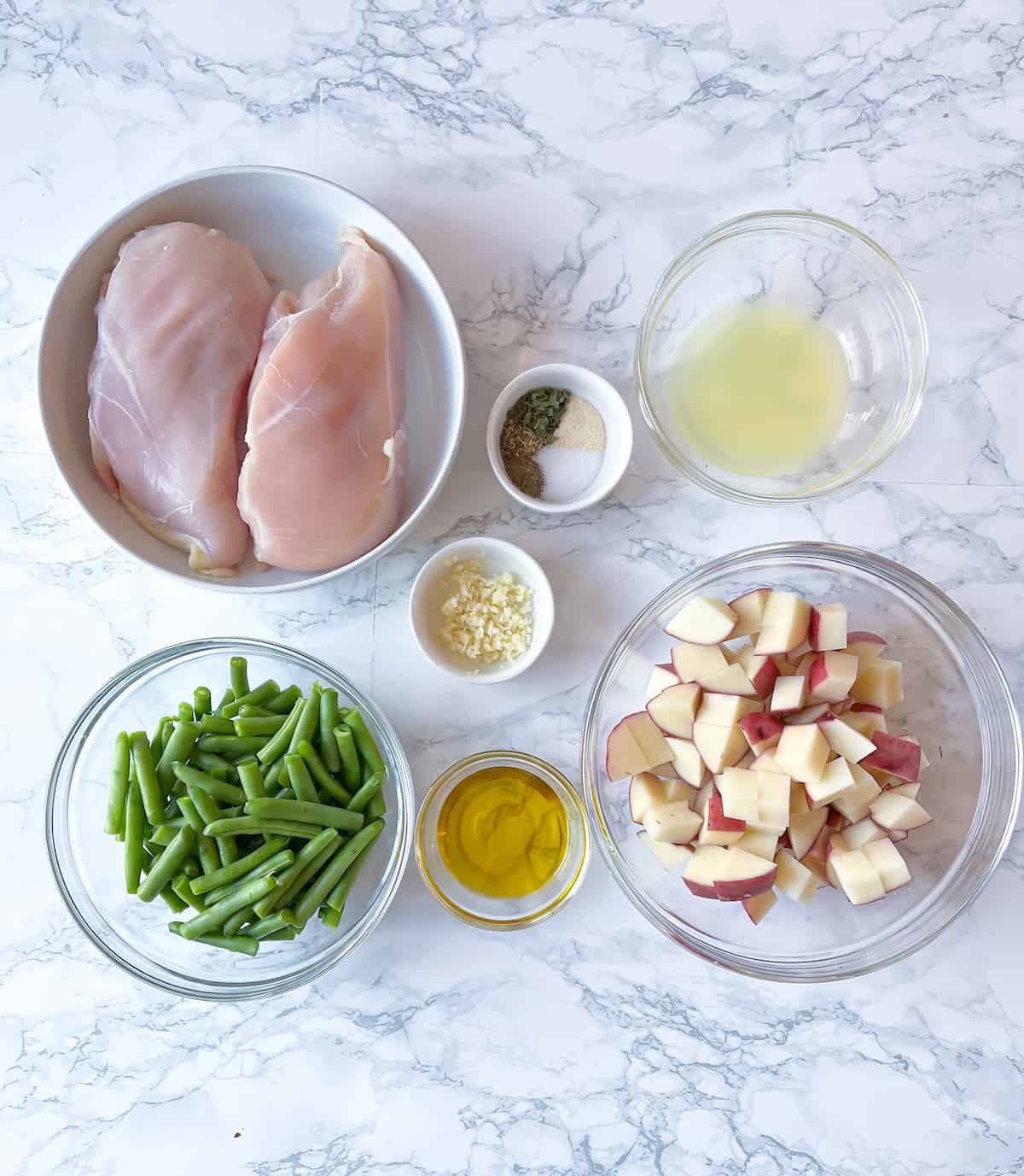Ingredients-chopped-for-slow-cooker-chicken-green-beans-and-potatoes-on-a-marble-table-1