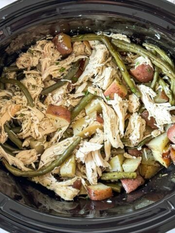 shredded slow cooker chicken, green beans and potatoes from an overhead view.