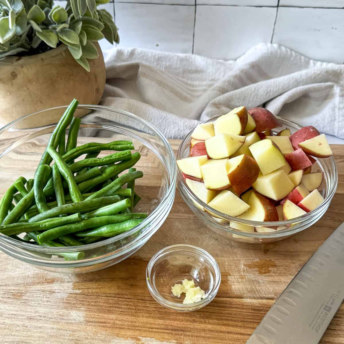 diced potatoes, green beans, and garlic in bowls.