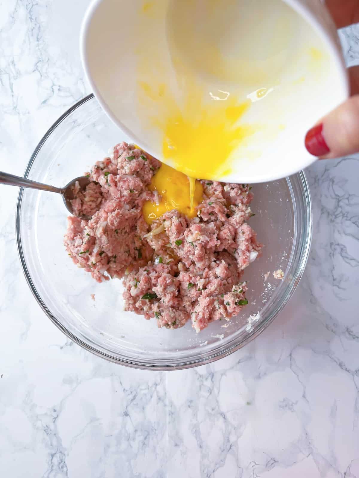 gluten-free turkey meatball mixture with egg being added to it
