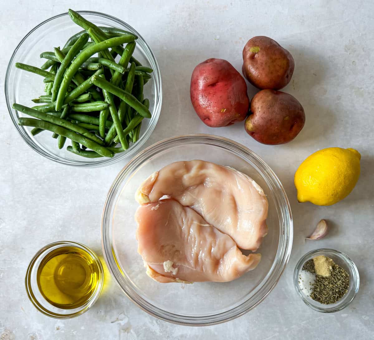 Ingredients for slow cooker chicken, green beans, and potatoes on a table.