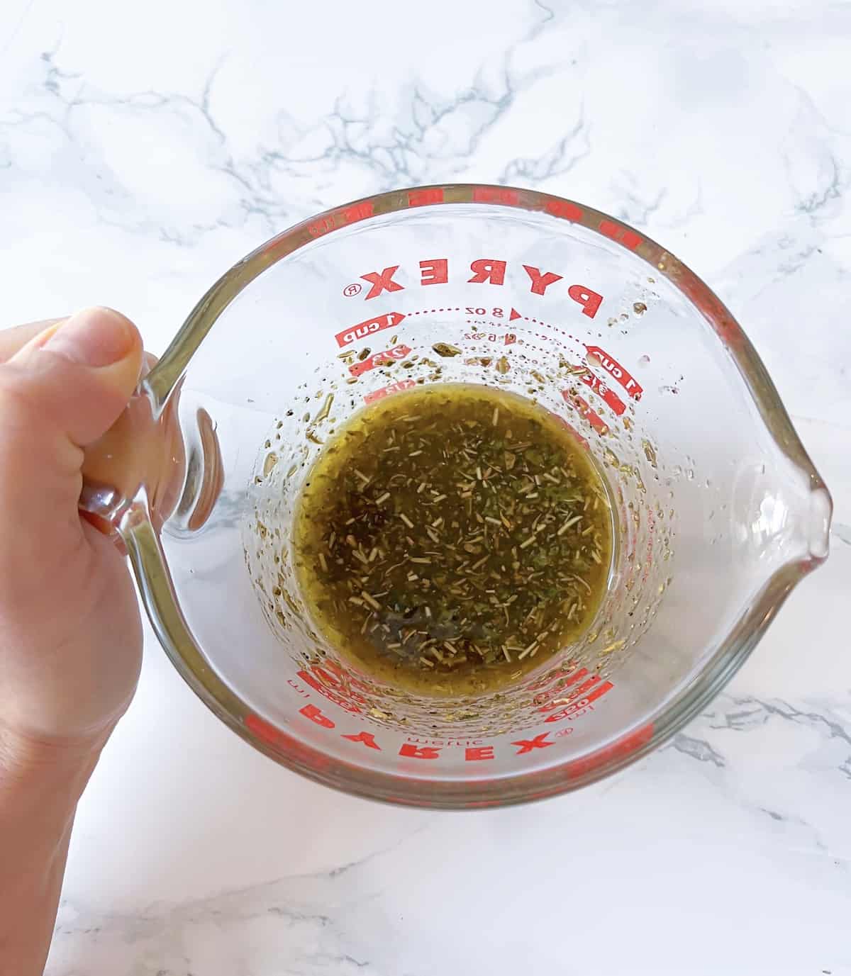 homemade italian dressing in a pyrex measuring cup