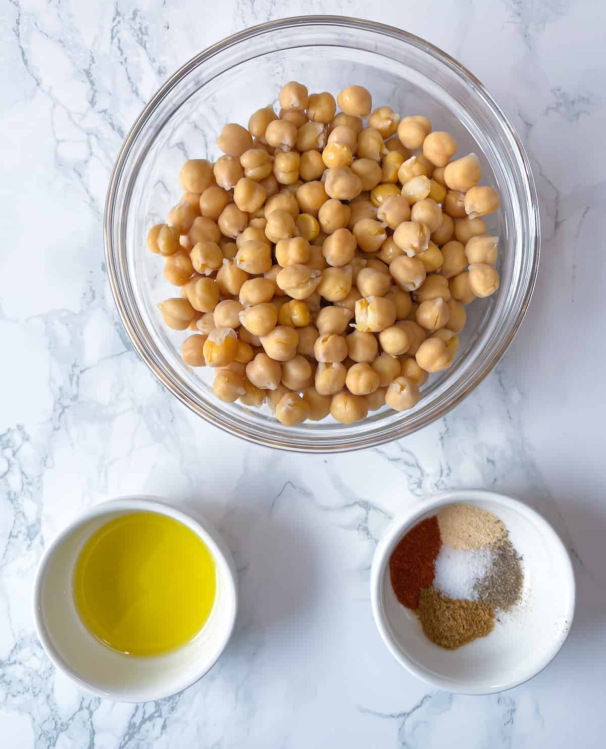 Ingredients for Mediterranean Roasted Chickpeas including canned chickpeas, extra-virgin olive oil, and a blend of spices