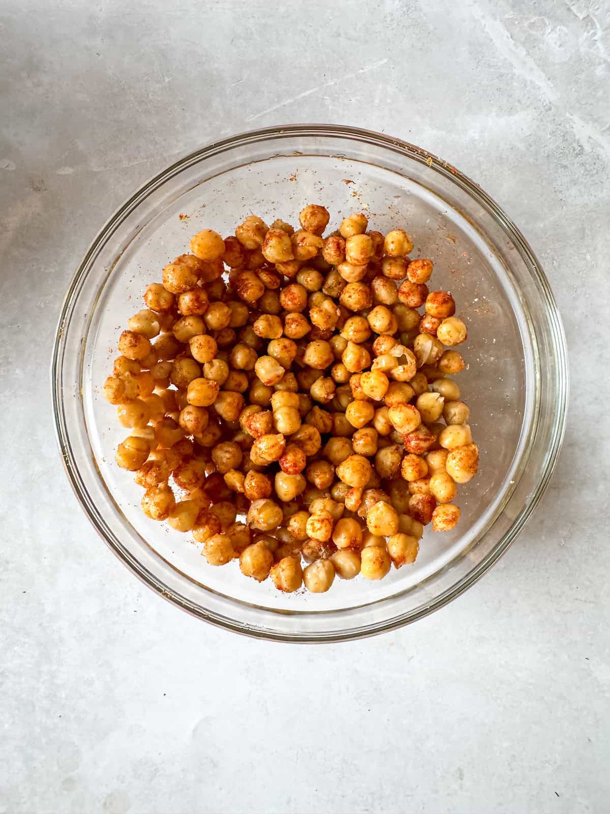 Chickpeas seasoned with spices in a glass bowl.