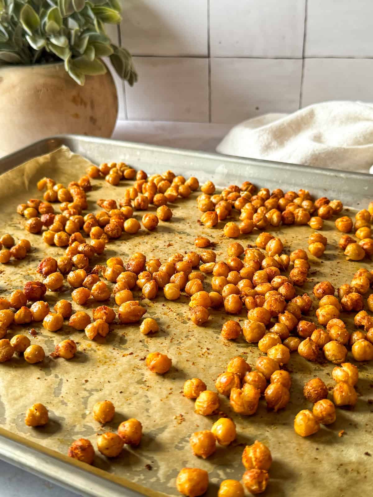 Roasted chickpeas fresh out of the oven on a baking sheet.