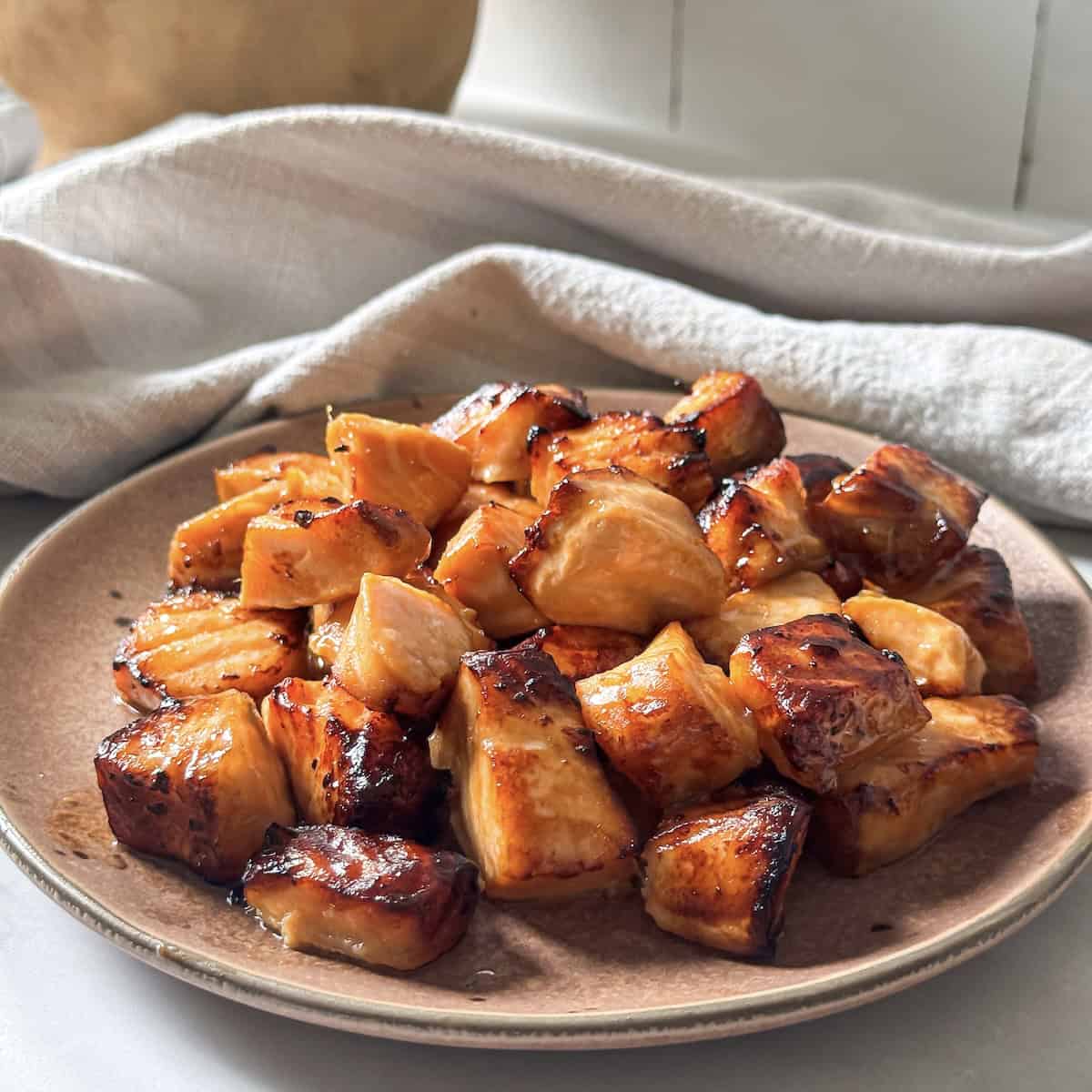 air fryer salmon bites on a plate side view.