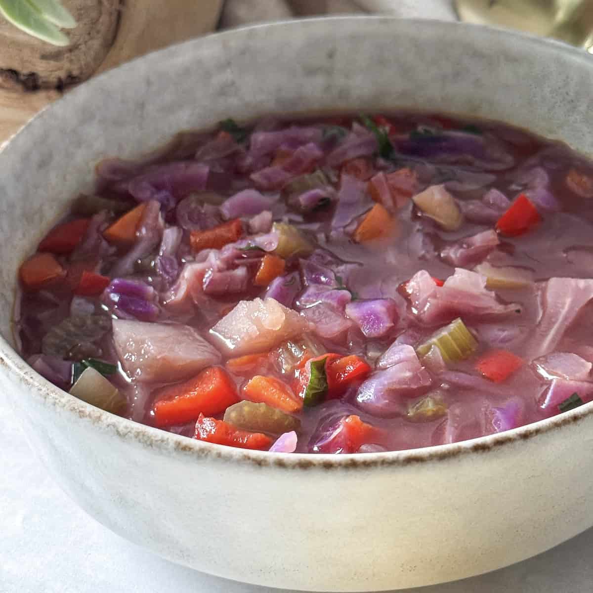 close up of red cabbage soup in a bowl.