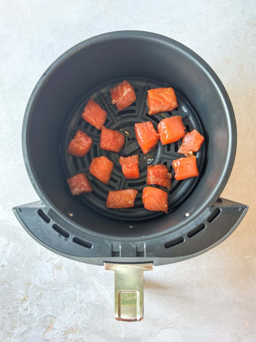 Air Fryer with Salmon Cubes in it.
