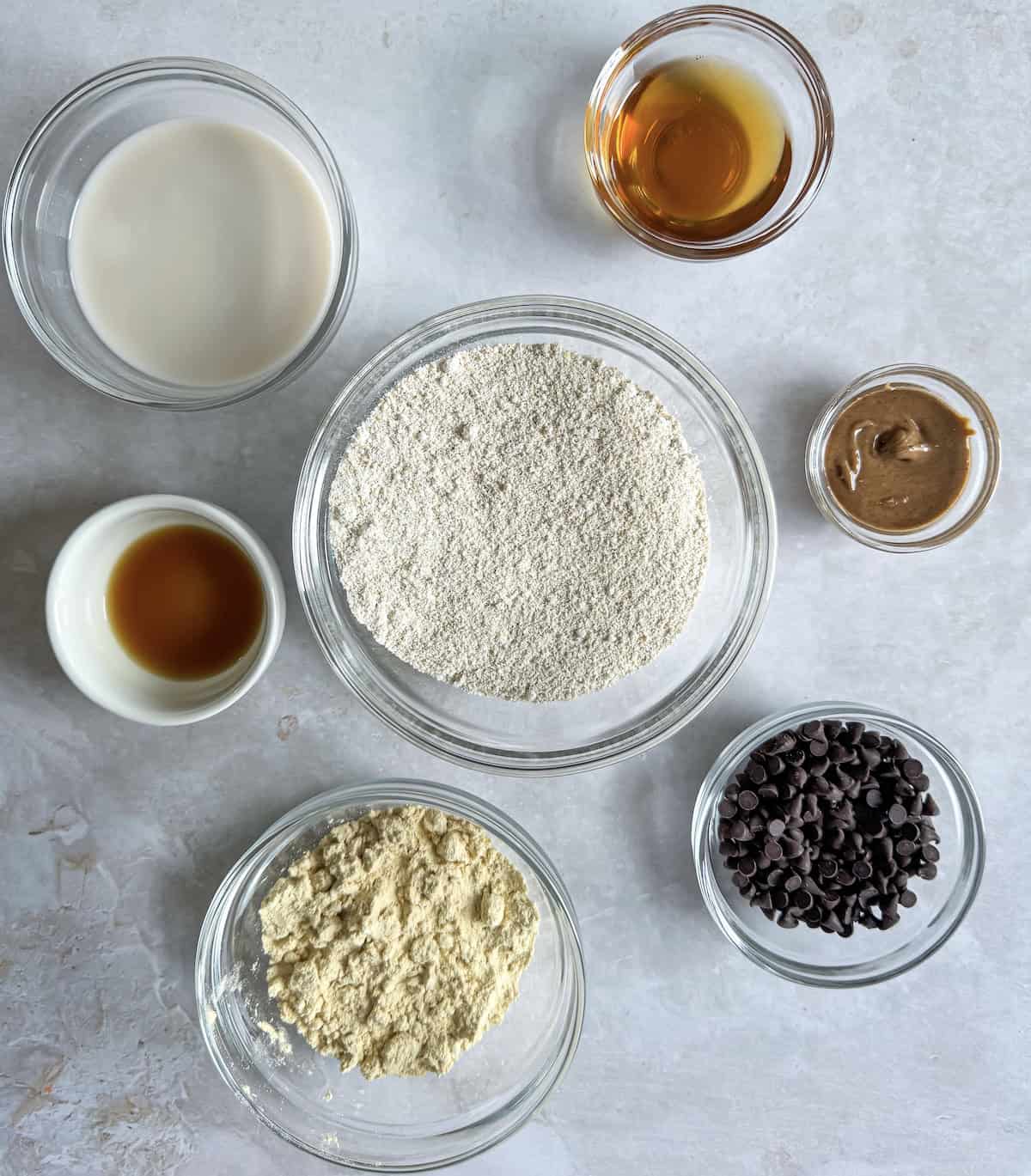 The ingredients for protein cookie dough balls in bowls on a table.