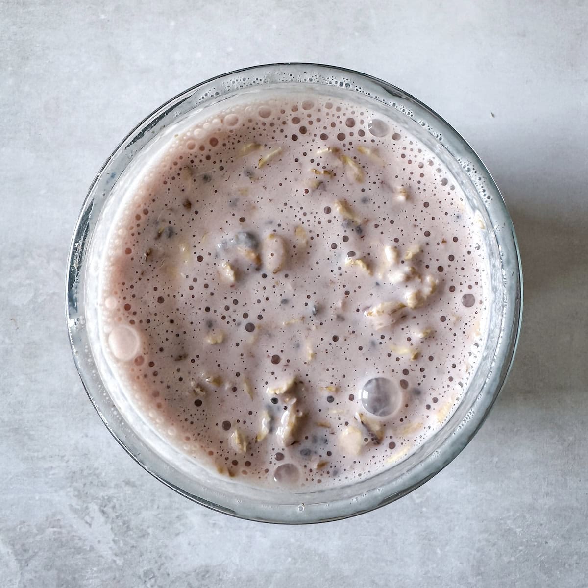 Strawberries mixed with oatmeal, chia seeds, yogurt, and milk.