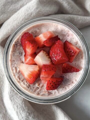 overhead view of strawberries and cream overnight oats in a mason jar.