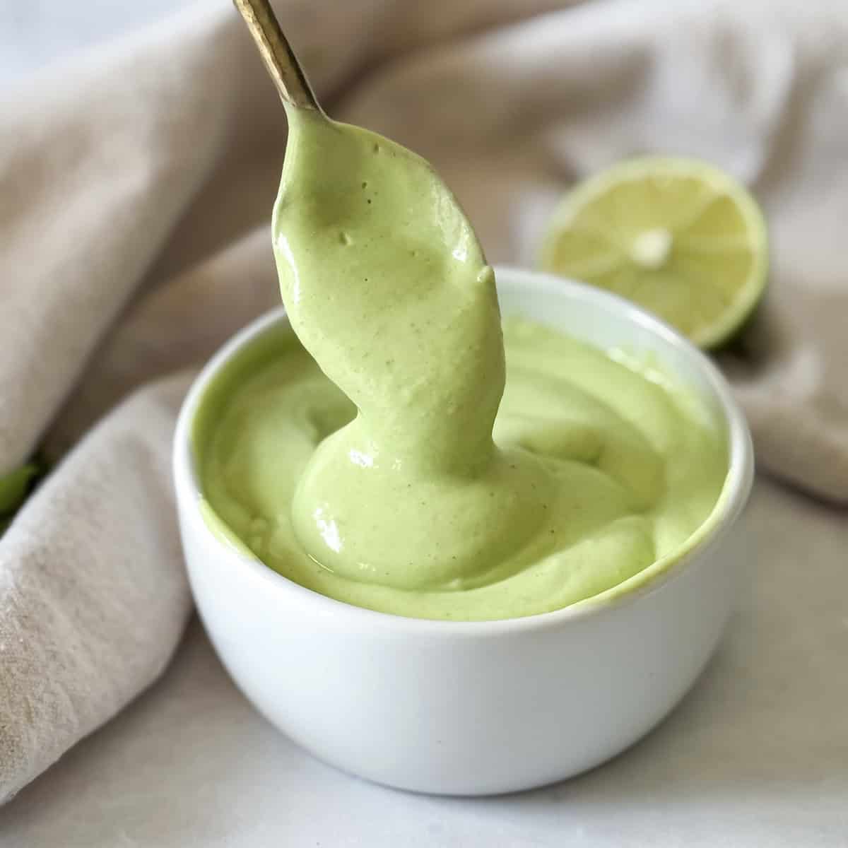 a spoon with a bite of avocado lime crema .