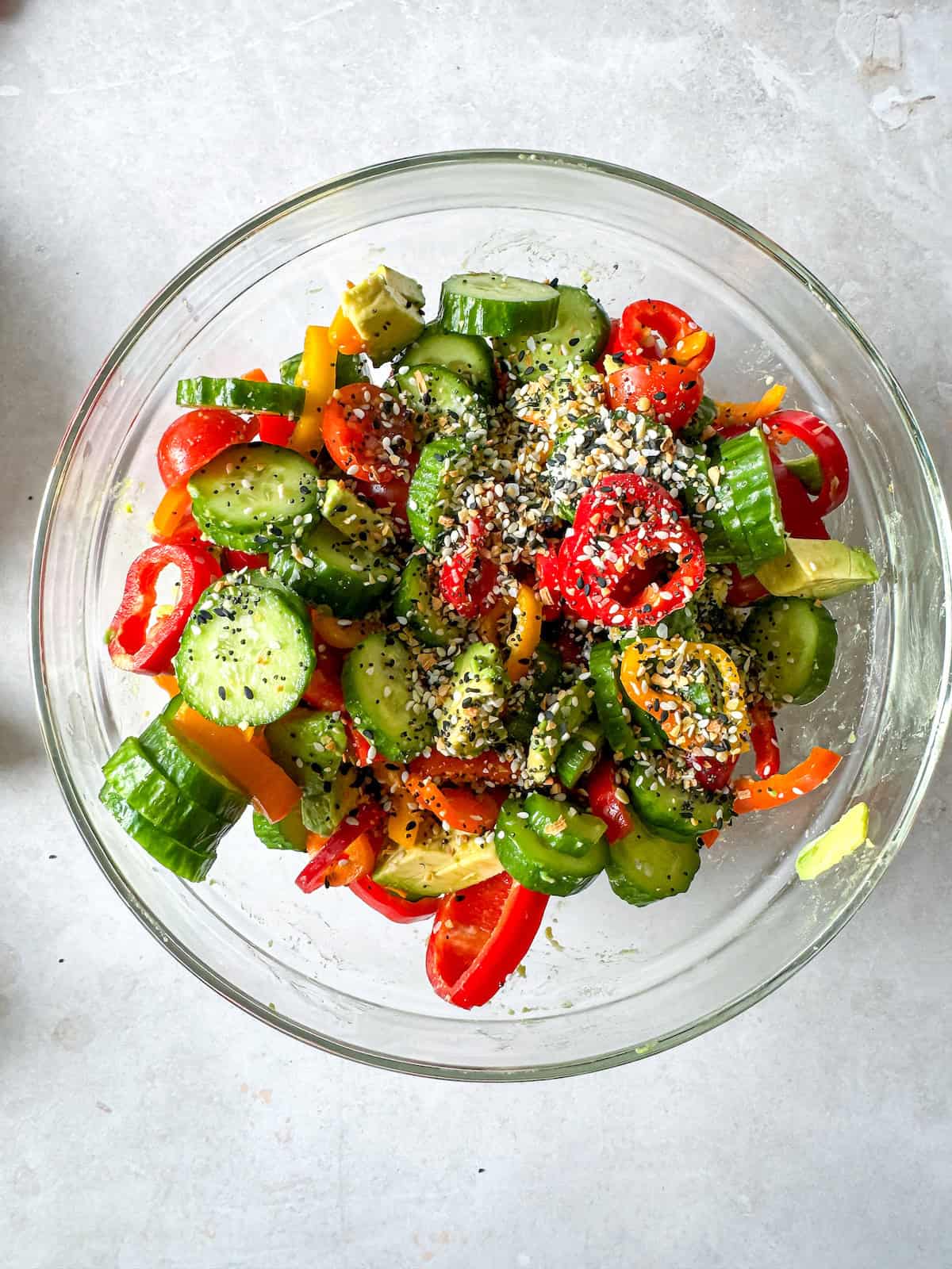 Cucumber slices, red peppers, and everything bagel seasoning in a bowl. 