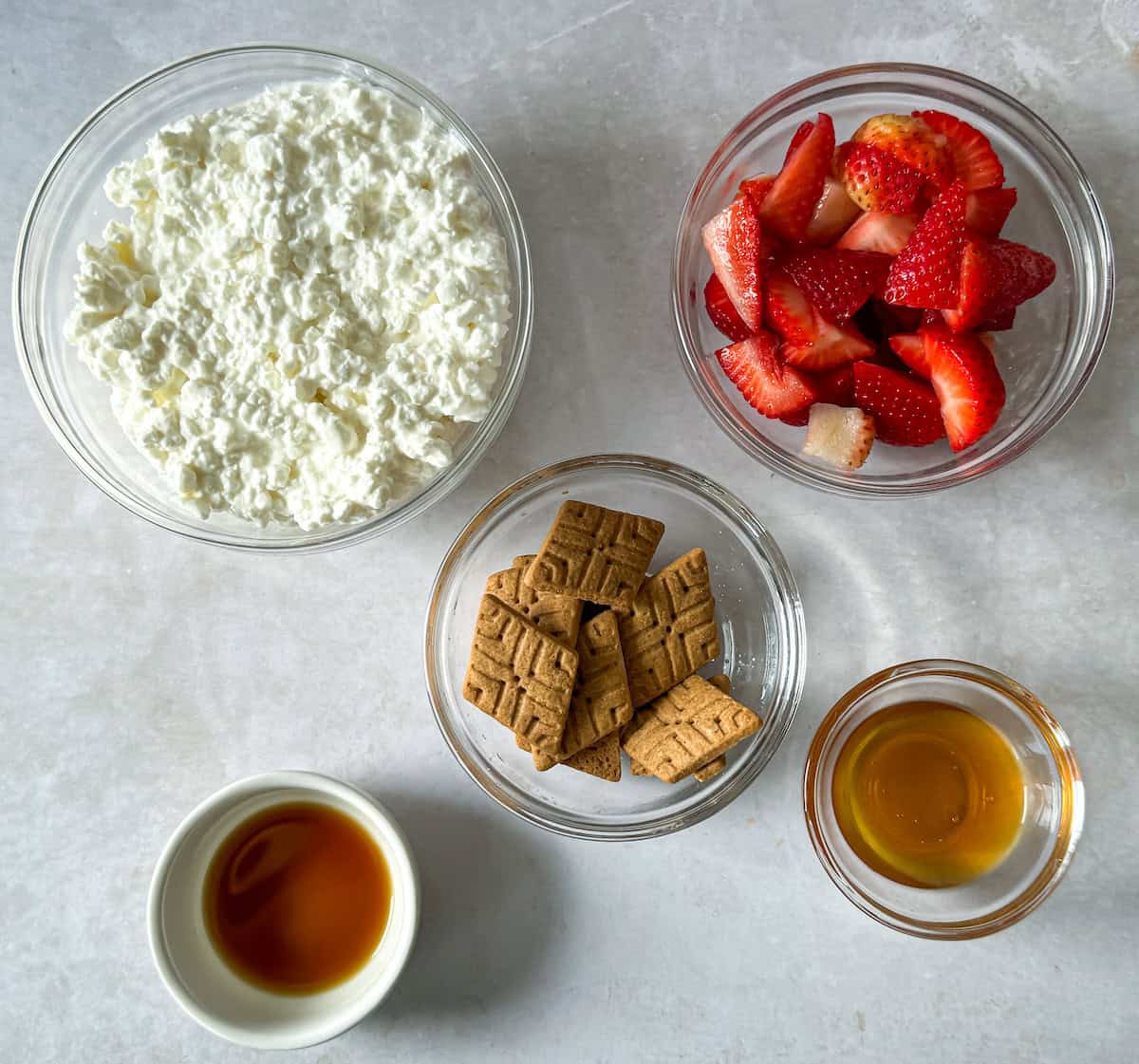 Ingredients to make Strawberry Cottage Cheese Ice cream on a table.