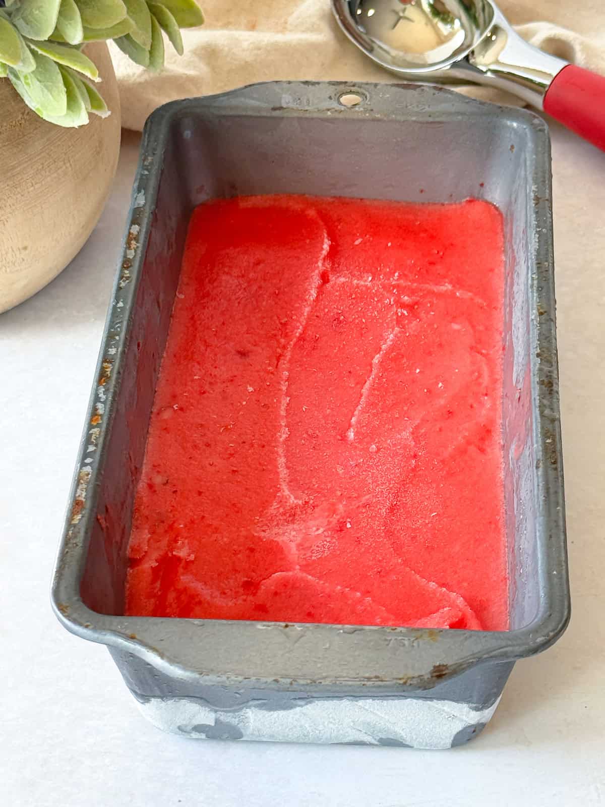 A loaf pan with the sorbet in it. It's a deep pink color.