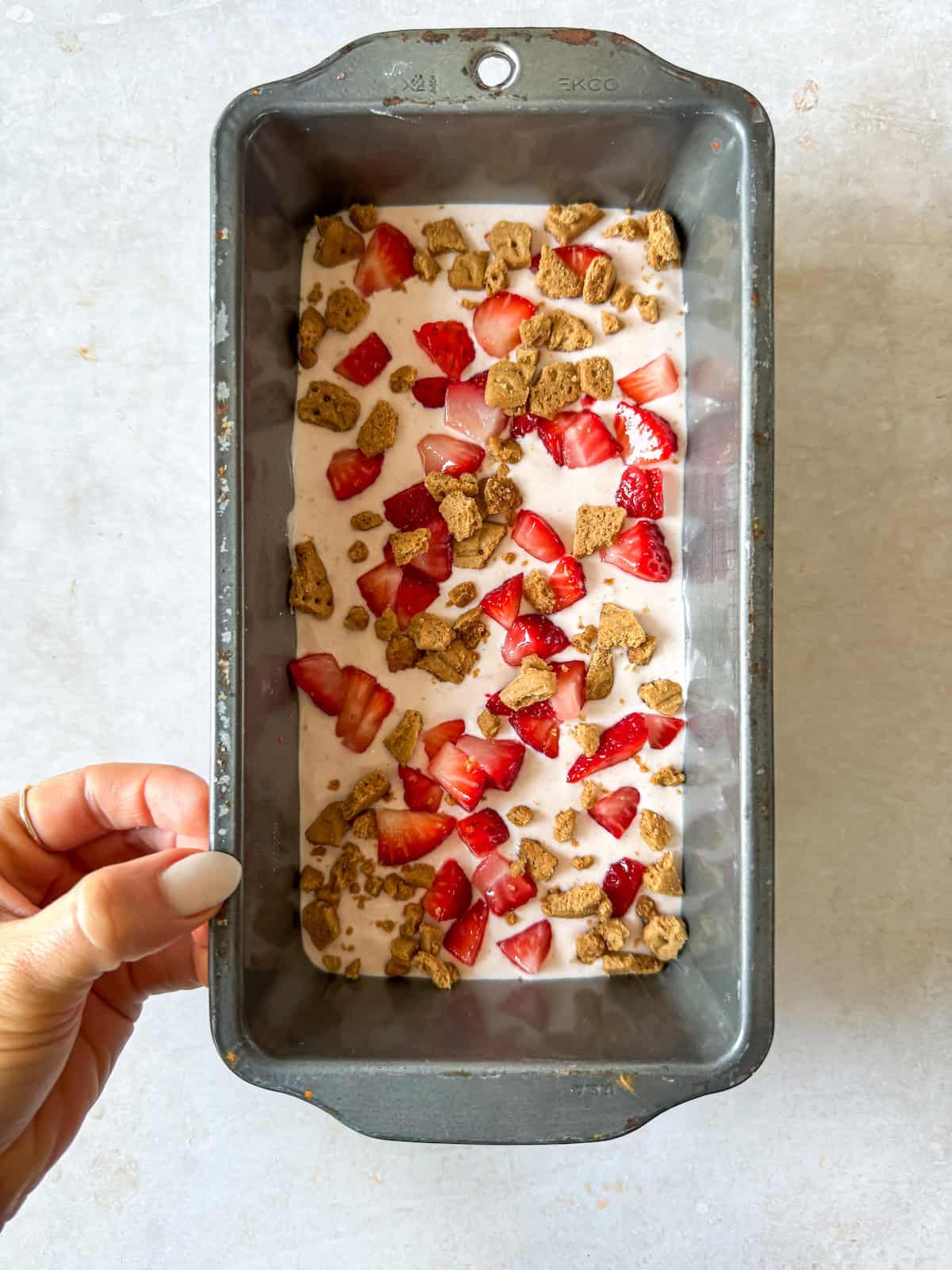 Strawberry cottage cheese ice cream topped with graham crackers and strawberries.