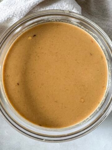 overhead view of peanut lime dressing in a glass bowl.