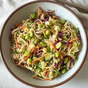 overhead view of spring roll in a bowl with edamame.