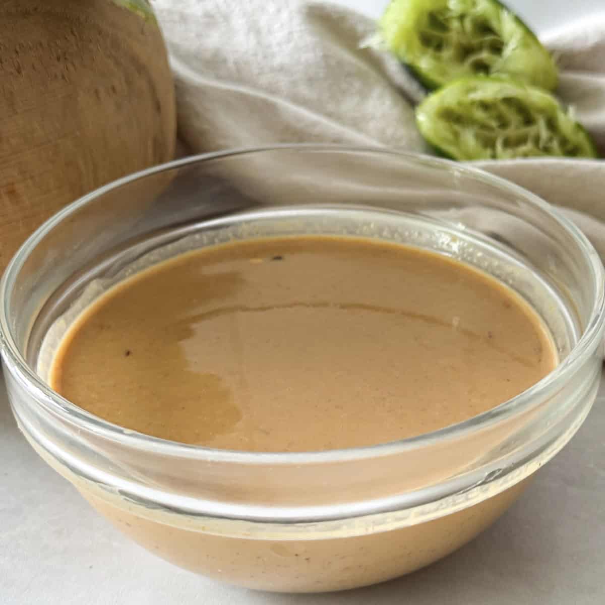 side view of peanut lime dressing in a glass bowl.