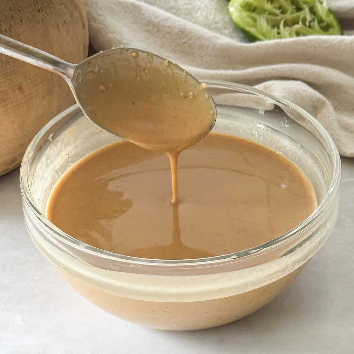 spoon with peanut lime dressing on it.