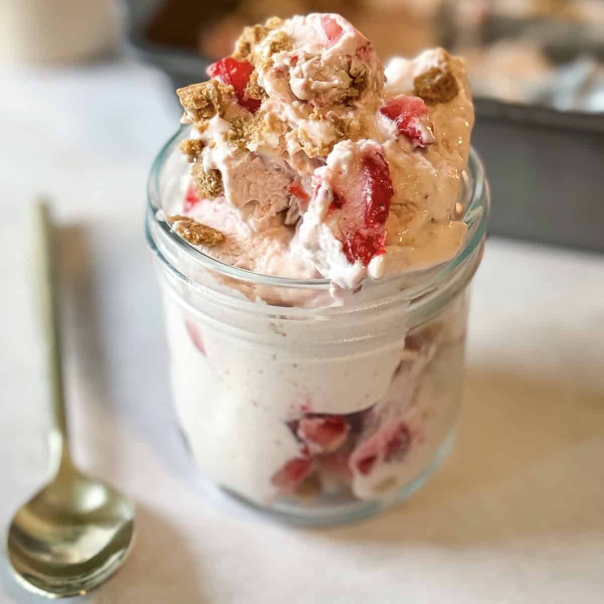 Strawberry Cottage cheese ice cream with a gold spoon next to it. 