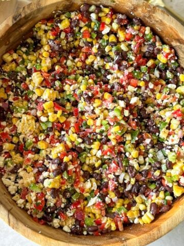 a wooden bowl with black bean and corn salsa overhead view.