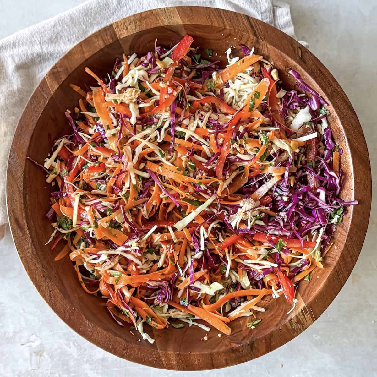 overhead view of asian crunch salad in a wooden bowl.