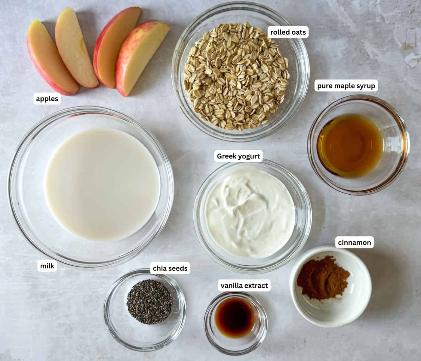 Ingredients for Apple Cinnamon Overnight Oats in separate container on a grayish white background.