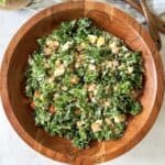 Kale and harvest salad in wooden bowl from an overhead view.