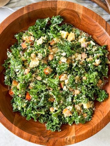 Kale and harvest salad in wooden bowl from an overhead view.