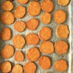 baked sweet potato slices on a baking sheet overhead view.