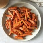 Honey glazed roasted carrots with thyme on a plate.