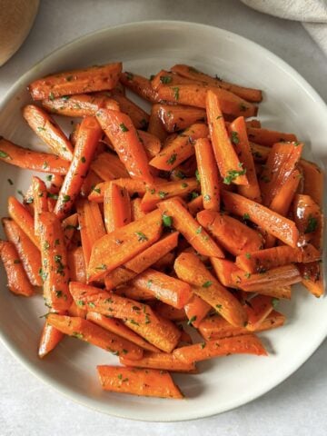 Honey glazed roasted carrots with thyme on a plate.