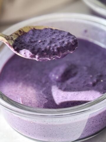 a spoon holding blueberry chia pudding.