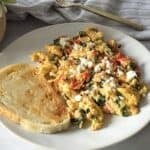 feta eggs scrambled on a plate with a slice of sourdough toast