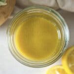 overhead view of lemon dijon dressing in a mason jar with lemons.